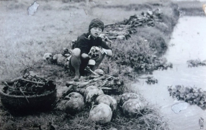 Một người làm từ thiện đang rửa xương của những nạn nhân chết đói. Ảnh: Võ An Ninh.